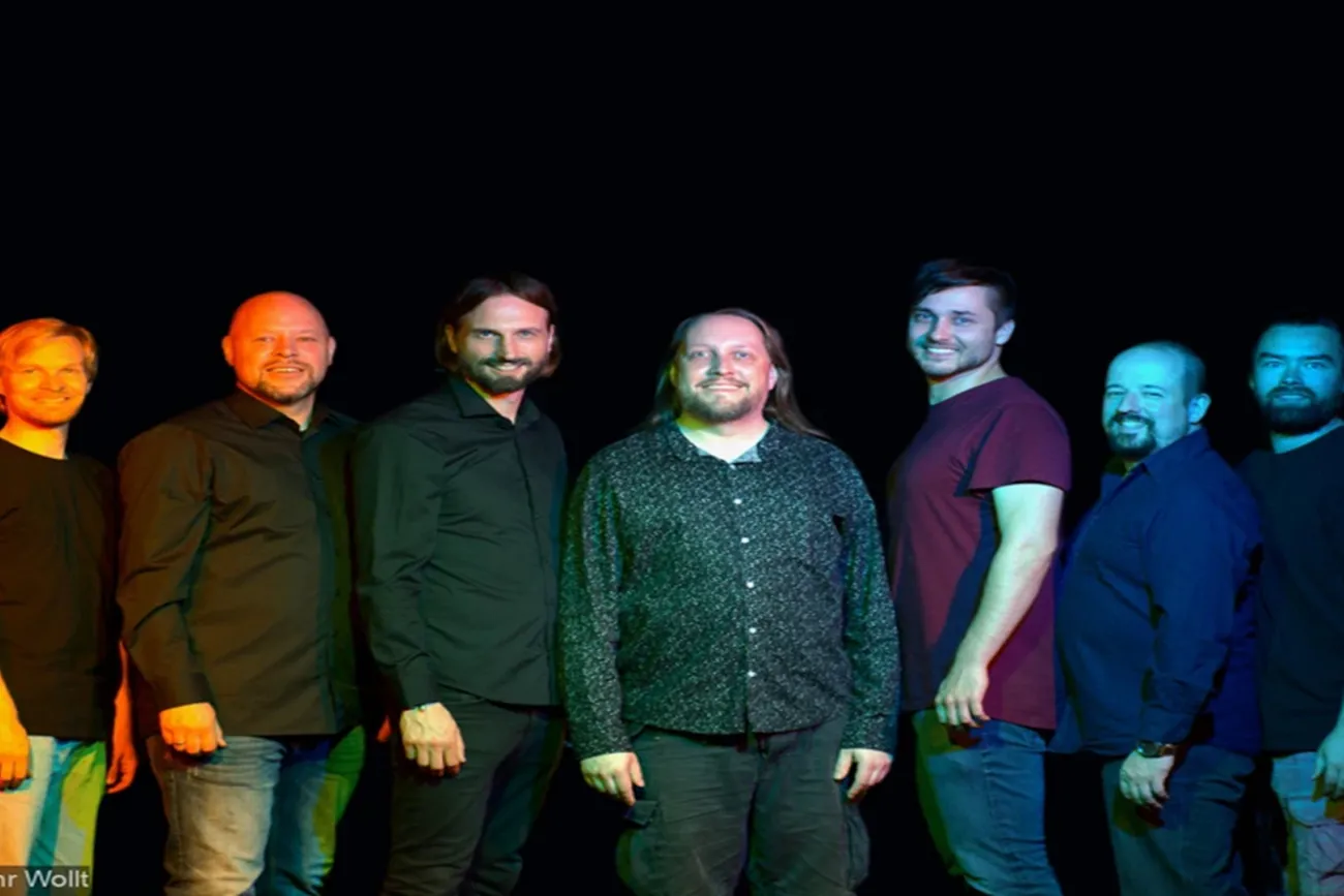 Die sieben Schauspieler des Improvisationstheaters Wat Ihr Wollt lächeln in die Kamera.