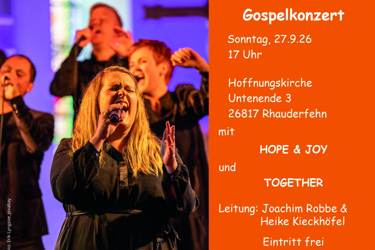 Gospelchor auf der Bühne, rechts orangefarbene Infotafel zum Konzert in Rhauderfehn.
