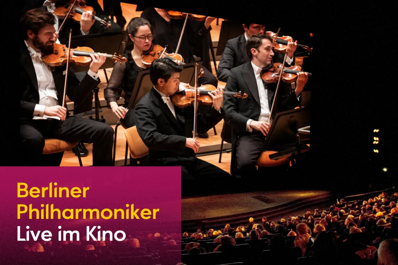 Berliner Philharmoniker live im Kino, Orchester auf Leinwand vor Publikum.