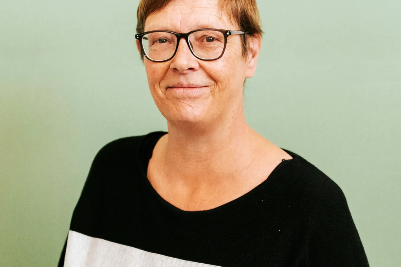 Frau mit kurzem Haar und schwarz-weißem Pullover