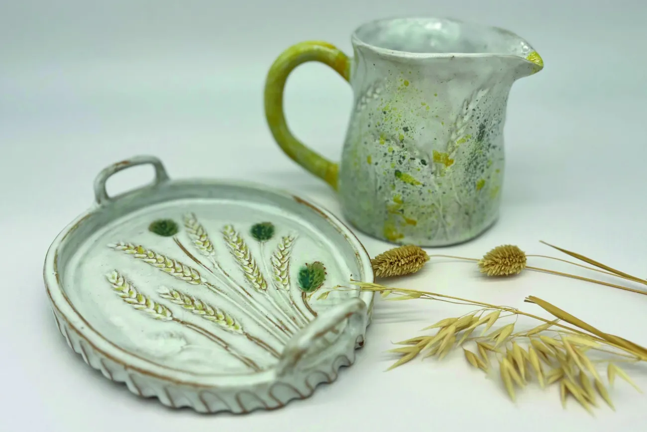 Ein getöpferter Kelch und ein Tablett mit einer Weizenpflanze