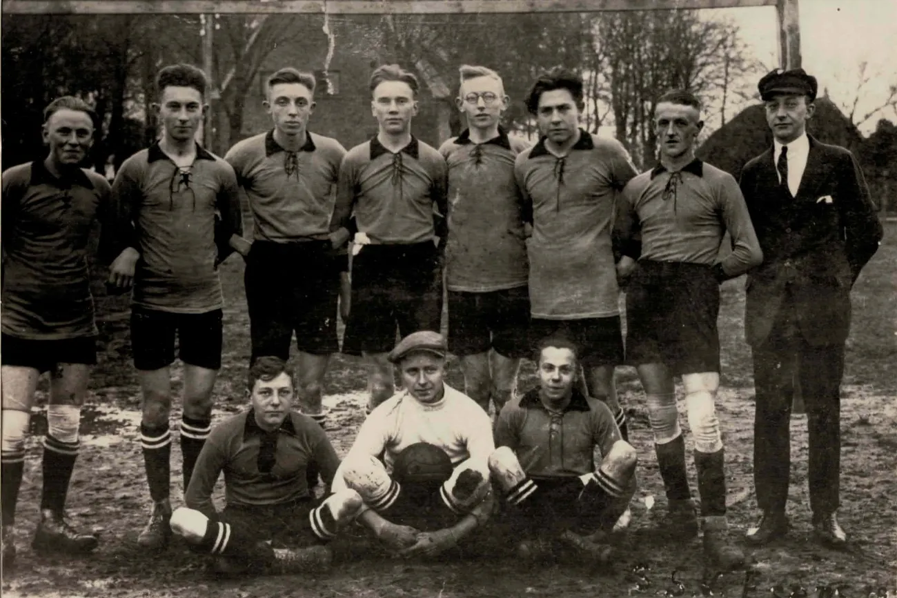 Schwarz-weiß Fotografie einer Fußballmannschaft von 1926. In der vorderen Reihe sitzen zwei Spieler und der Torwart mit dem Ball in der Hand. Hinter ihnen stehen sieben Spieler und der Trainer.