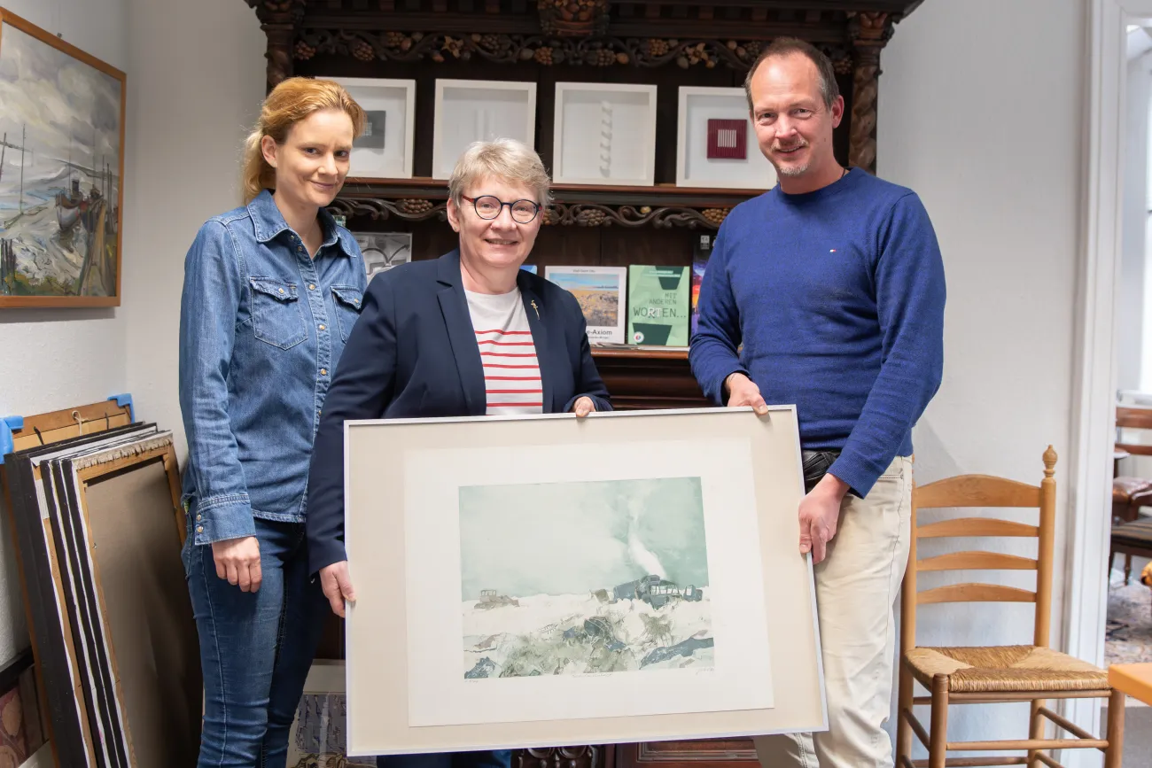 Bild von Dieter Zirkel wird überreicht von Dr. Welf‑Gerrit Otto an Dr. Edith Ulferts, Fachbereichsleiterin der Stadt Aurich, sowie Sonja Hohnholt, Leiterin der Stadtbücherei Aurich