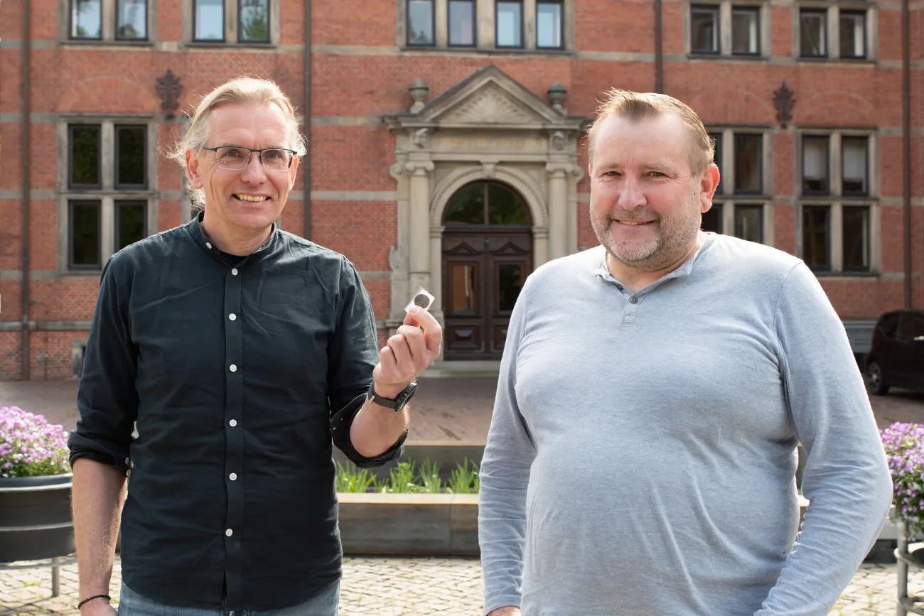 Jan Kegler nimmt die historische Münze von Wilfried Ottersberg entgegen.