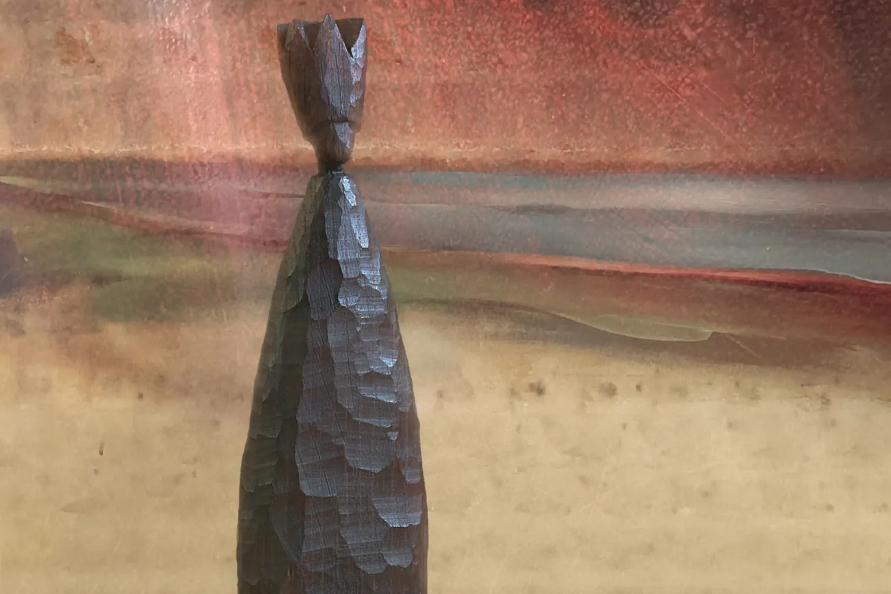 Zusehen ist das Ausstellungsplakat. Ein schlichte, schlanke Figur steht im Vordergrund. Im Hintergrund sieht man ein angedeutetes Augenpaar.