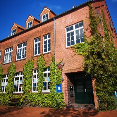 Außenansicht der Kunstschule der Kulturwerkstatt, ein schönes mit Efeu bewachsenen, rotes Haus mit großen Fenstern