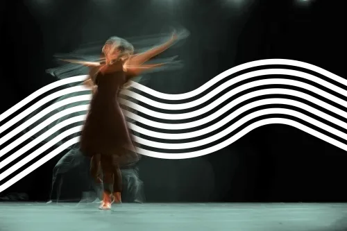 Kreiselnde Tänzerin bewegt sich wild vor schwarzer Wand