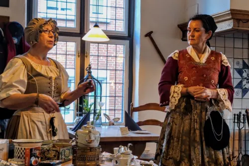 Zwei Frauen in historischer Kleidung erzählen bei Tee und Gebäck Geschichten in plattdeutscher Sprache.