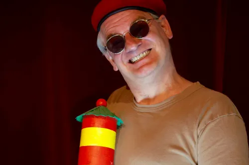 Comedian Ausbilder Schmidt mit roter Mütze und Leuchtturm-Requisite auf der Bühne