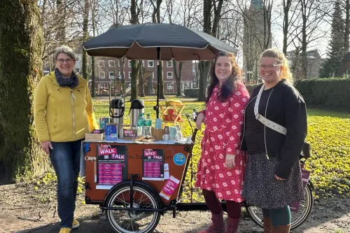 Drei Frauen stehen bei einem Lastenrad mit Schirm und Getränken in Emden.