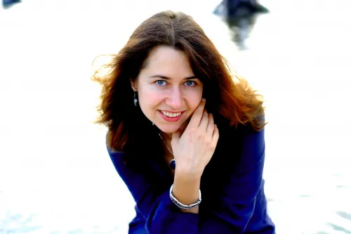 Porträt der lächelnden Pianistin Anna Zassimova in blauer Bluse.