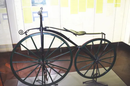 Historisches Fahrrad mit großem Vorderrad in einer Ausstellung der Evenburg.