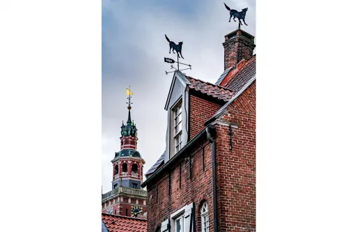 Backsteingiebel mit Wetterfahnen vor dem Rathausturm in Leer.