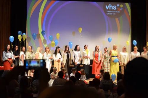 Gruppe von Sängerinnen auf Bühne mit Luftballons