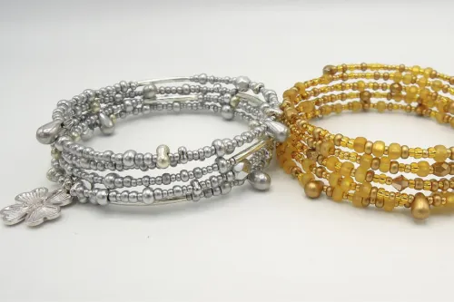 zwei Armbänder, jeweils in Gold und Silber, mit vielen Anhängern