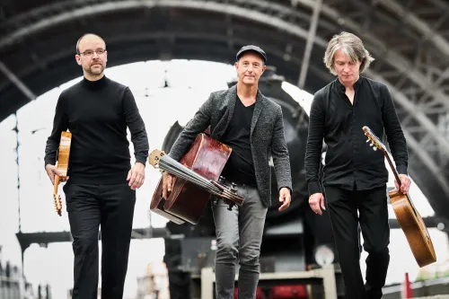 Zusehen sind die drei Musiker.