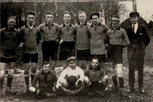 Schwarz-weiß Fotografie einer Fußballmannschaft von 1926. In der vorderen Reihe sitzen zwei Spieler und der Torwart mit dem Ball in der Hand. Hinter ihnen stehen sieben Spieler und der Trainer.