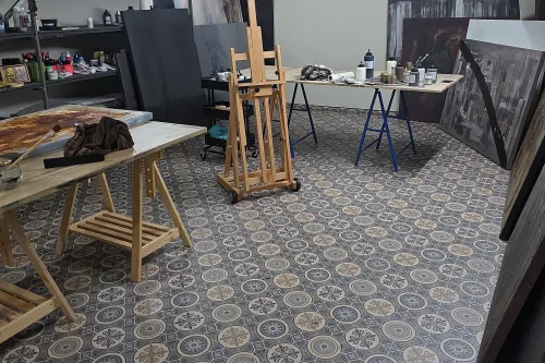 Heller Atelierraum mit gemustertem Boden, Staffeleien und ausgestellten Kunstwerken für das Atelierwochenende „Künstlerische Begegnungen“.