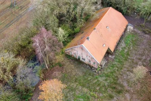 Gulfhof aus der Vogelperspektive, umgeben von Feldern und Bäumen