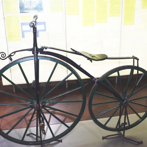 Historisches Fahrrad mit großem Vorderrad in einer Ausstellung der Evenburg.