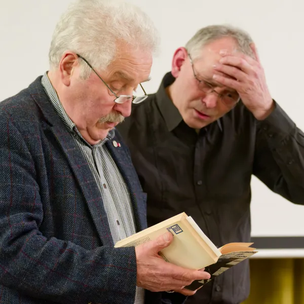 Rico Mecklenburg und Stephan-Gerhard Koziolek (NfG-Direktor) blättern in seinem Lebensbuch