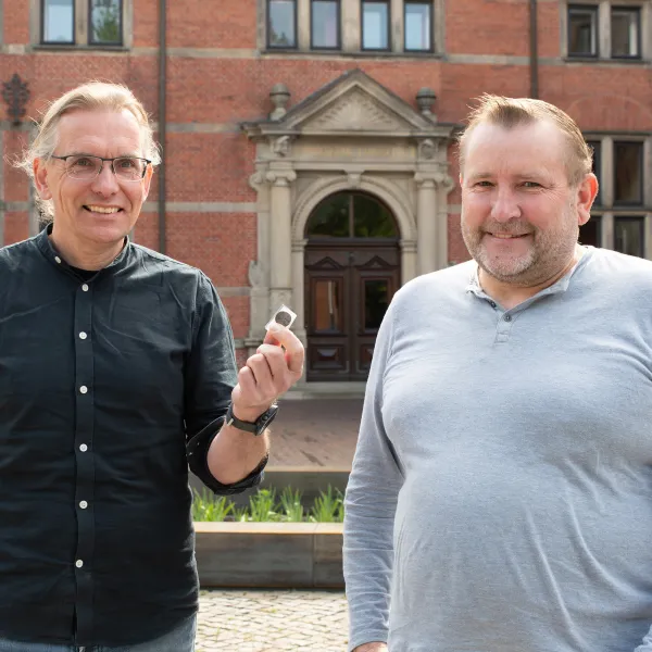 Jan Kegler nimmt die historische Münze von Wilfried Ottersberg entgegen.