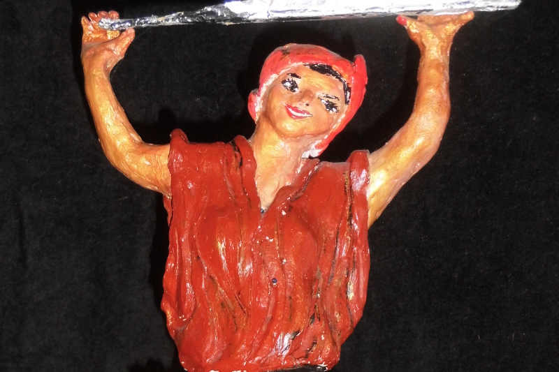 Bunte Raku-Keramikfigur einer lächelnden Person mit hoch erhobenen Armen und silbernem Objekt.