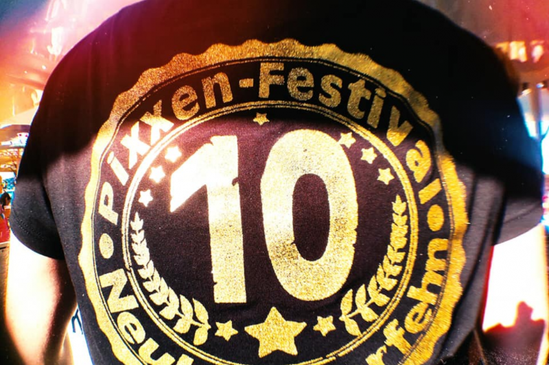 Person mit T-Shirt zeigt das "Pixxen-Festival Neukamperfehn" Logo zum 10-jährigen Jubiläum.