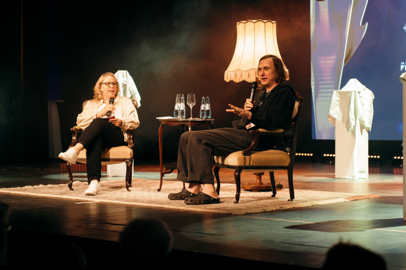 Der Filmtalk beim Emder Filmfest 2024: Lars Eidinger und die Moderatorin auf Sesseln auf der Bühne.