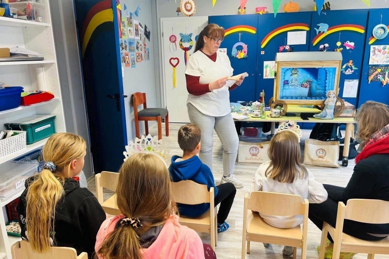 Lesung im bunten Zimmer vom Lükko-Leuchtturm-Kinderhaus. Einige Kinder hören gespannt zu.