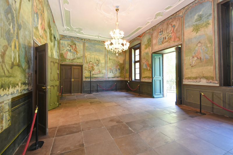 Der Freskensaal mit den historischen Wandmalereien und offener Haupteingangstür