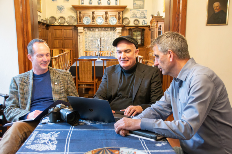 Drei Männer sitzen vor einem Laptop