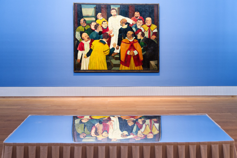 Spiegelnde Bank vor dem Bild „Blinder Bettler im Café“ von Josef Scharl