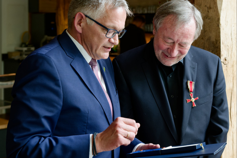 Der frisch Geehrte trägt das Bundesverdienstkreuz