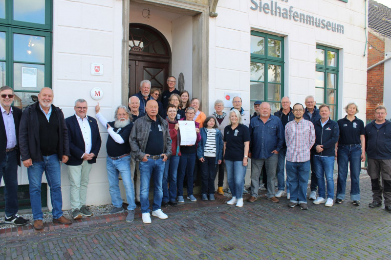Das muss gefeiert werden! Mitarbeiter des Sielhafenmuseums freuen sich über die Auszeichnung mit dem Museumsgütesiegel.