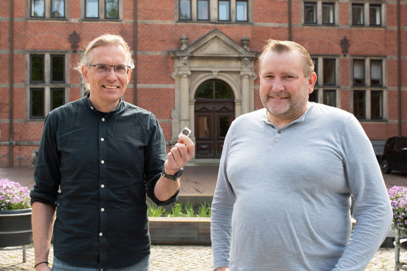 Jan Kegler nimmt die historische Münze von Wilfried Ottersberg entgegen.