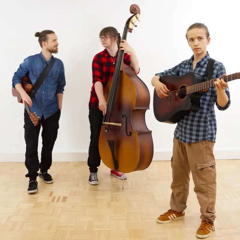 Auf dem Bild sieht man 3 Musiker mit verschiedenen Instrumenten.