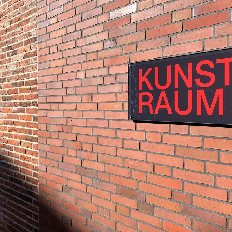 Das Foto zeigt das Schild Kunstraum Pilsum an der dortigen Hauswand.