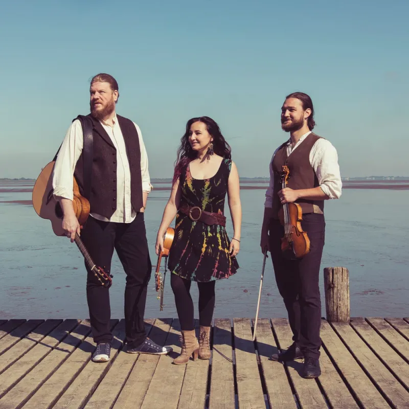 Die Band "La Kejoca" (3 Personen: ein Mann, eine Frau, ein Mann) steht auf einem Steg.