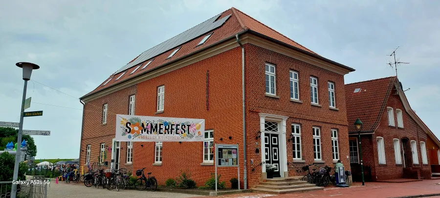 Sommerfest-Banner neben einem großen Haus