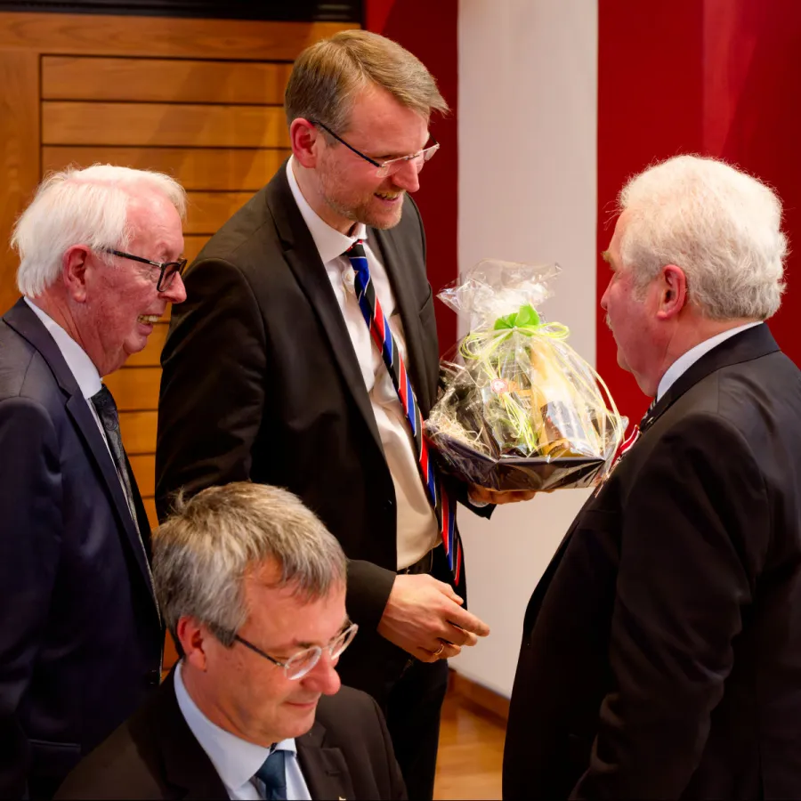Gratulation von der Ostfriesischen Landschaft: Landschaftsdirektor Dr.  Matthias Stenger und der stellvertretende Landschaftspräsident Hilko Gerdes, sitzend: Staatssekretär Johann Saathoff. 