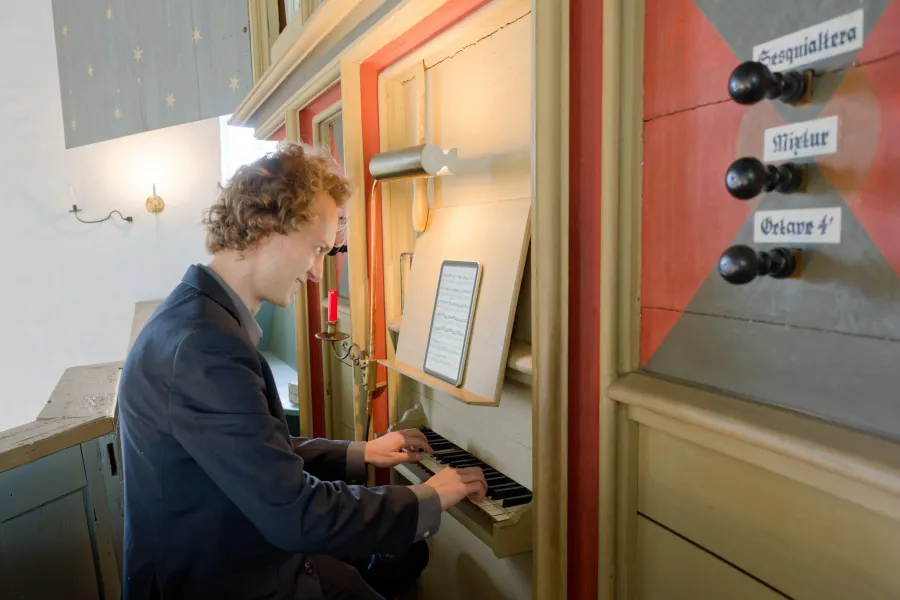 Michael Bennett an der Rysumer Orgel mit ihrem einen Manual und den sieben Registern, von denen vier noch original aus der Gotik stammen