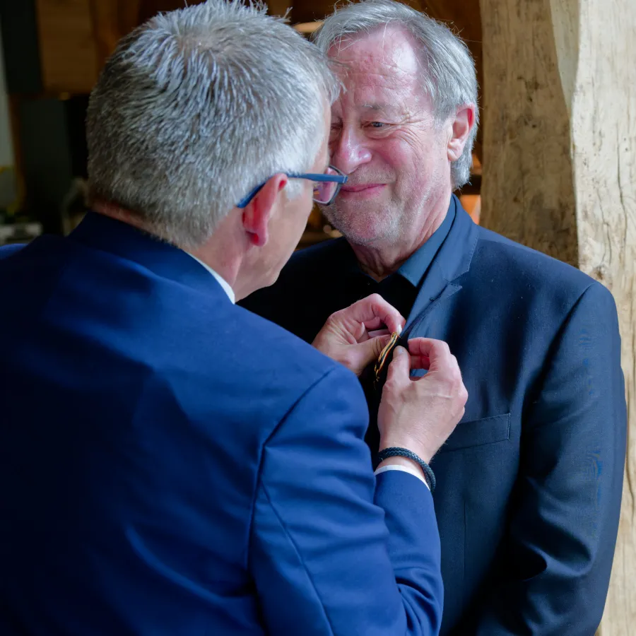 Olaf Meinen heftet das Verdienstkreuz an das Revers von Herbert Müller