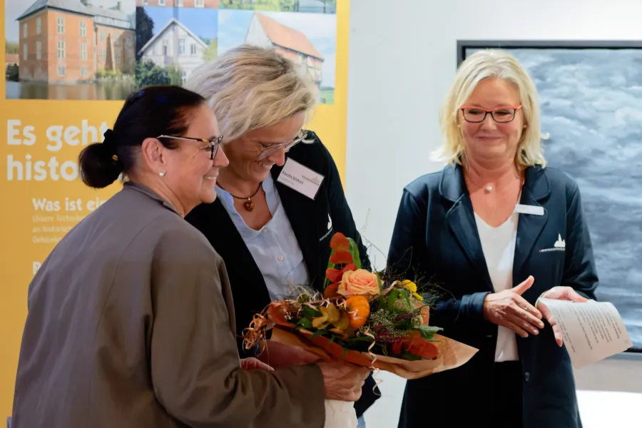 Blumen für die Referenten überreichten die beiden Projektleiterinnen des Monumentendienstes Kerstin Stölken und Bente Juhl. Hier ist Luise Fauerbach-Geiken die Empfängerin